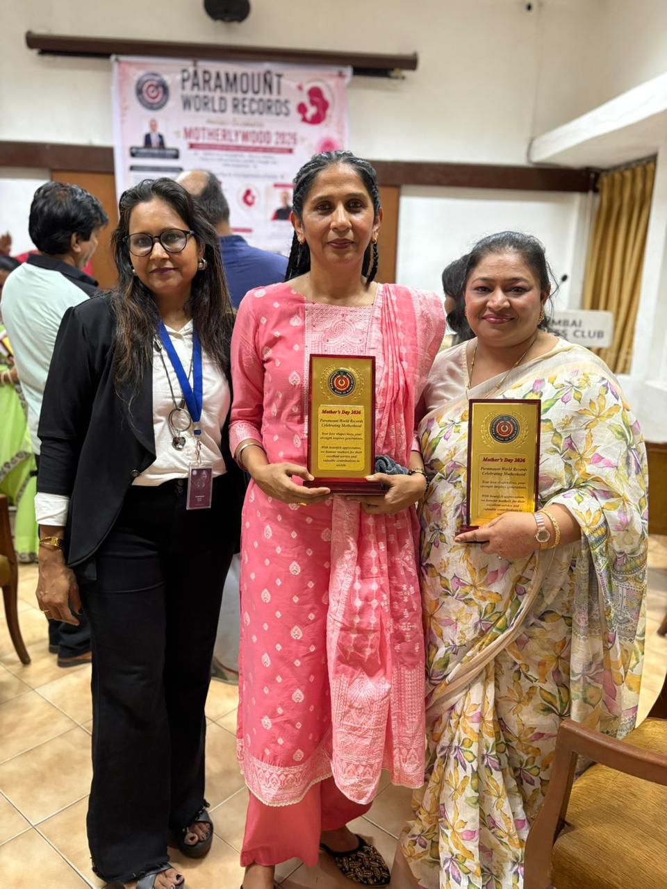 Award recipients holding recognition plaques at the Mother's Day ceremony